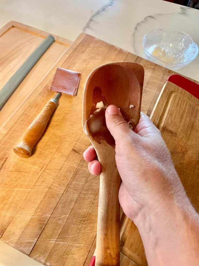 applying coconut oil to a wooden spoon for deep cleaning