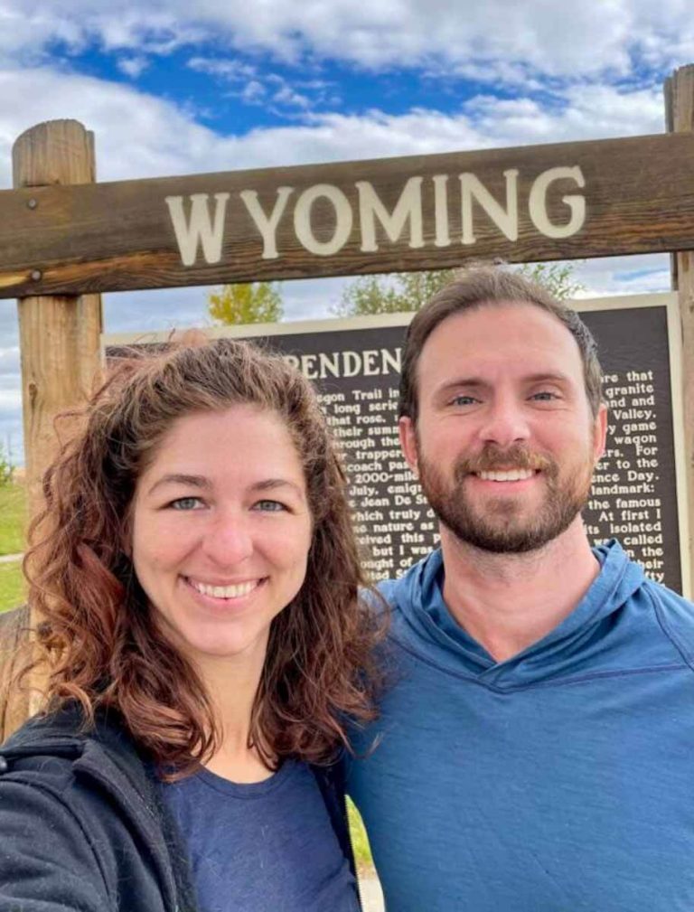 two people in front of a wyoming sign - how to homestead